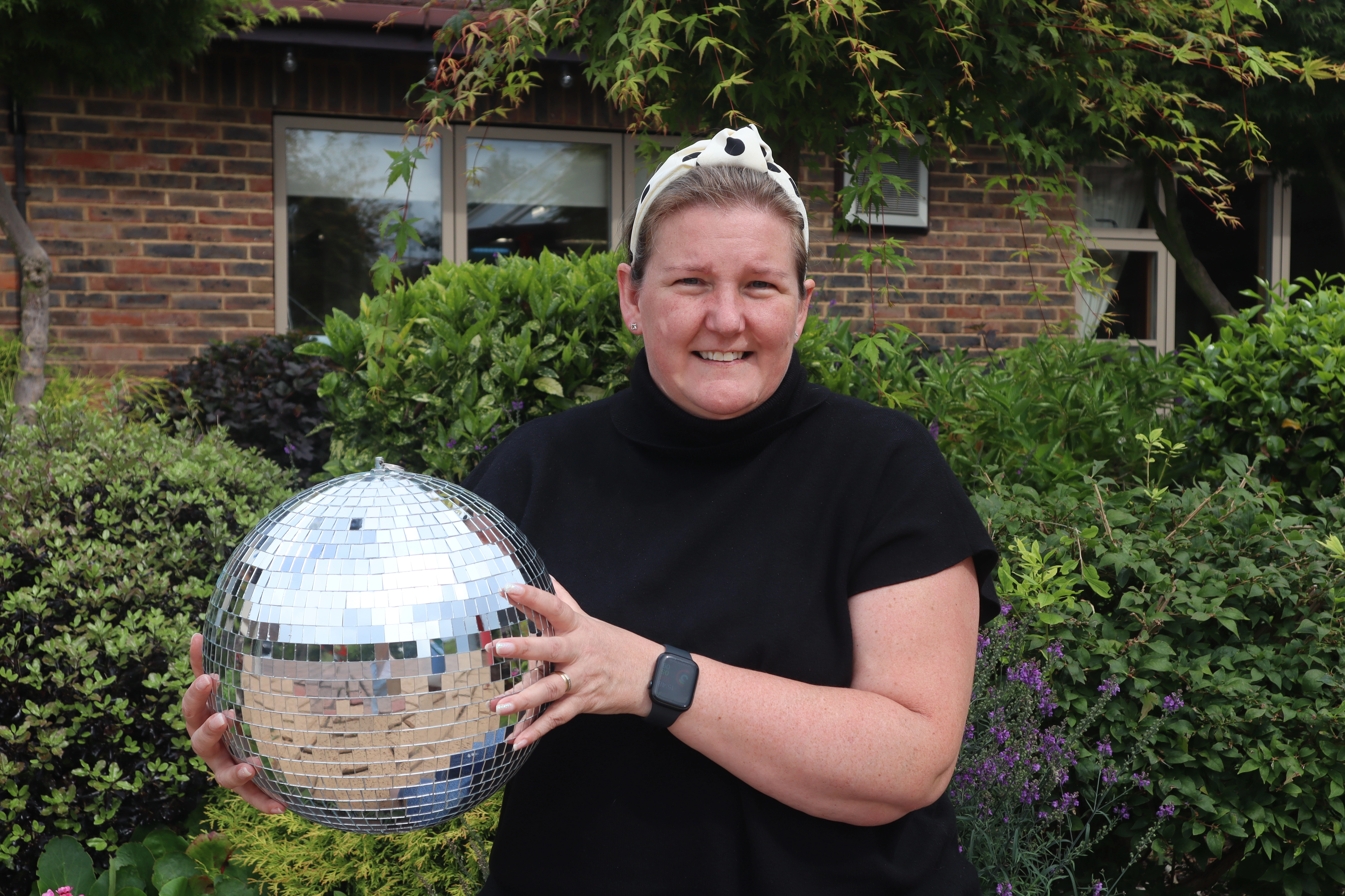 A photo of Sarah holding the Strictly St. Rocco's Glitter ball