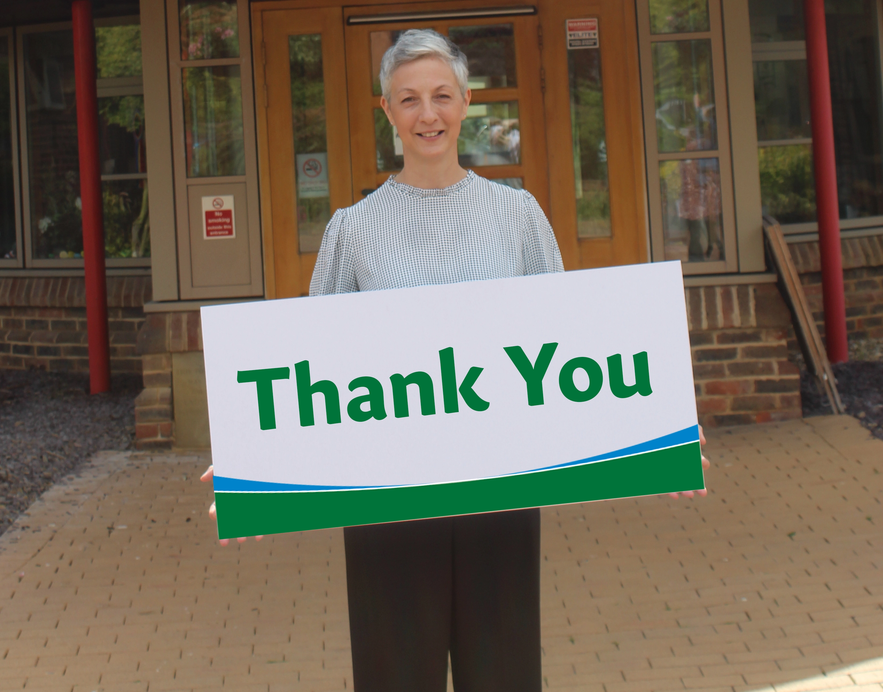 A photo of St. Rocco's CEO Sonya holding up a sign that says "Thank You"