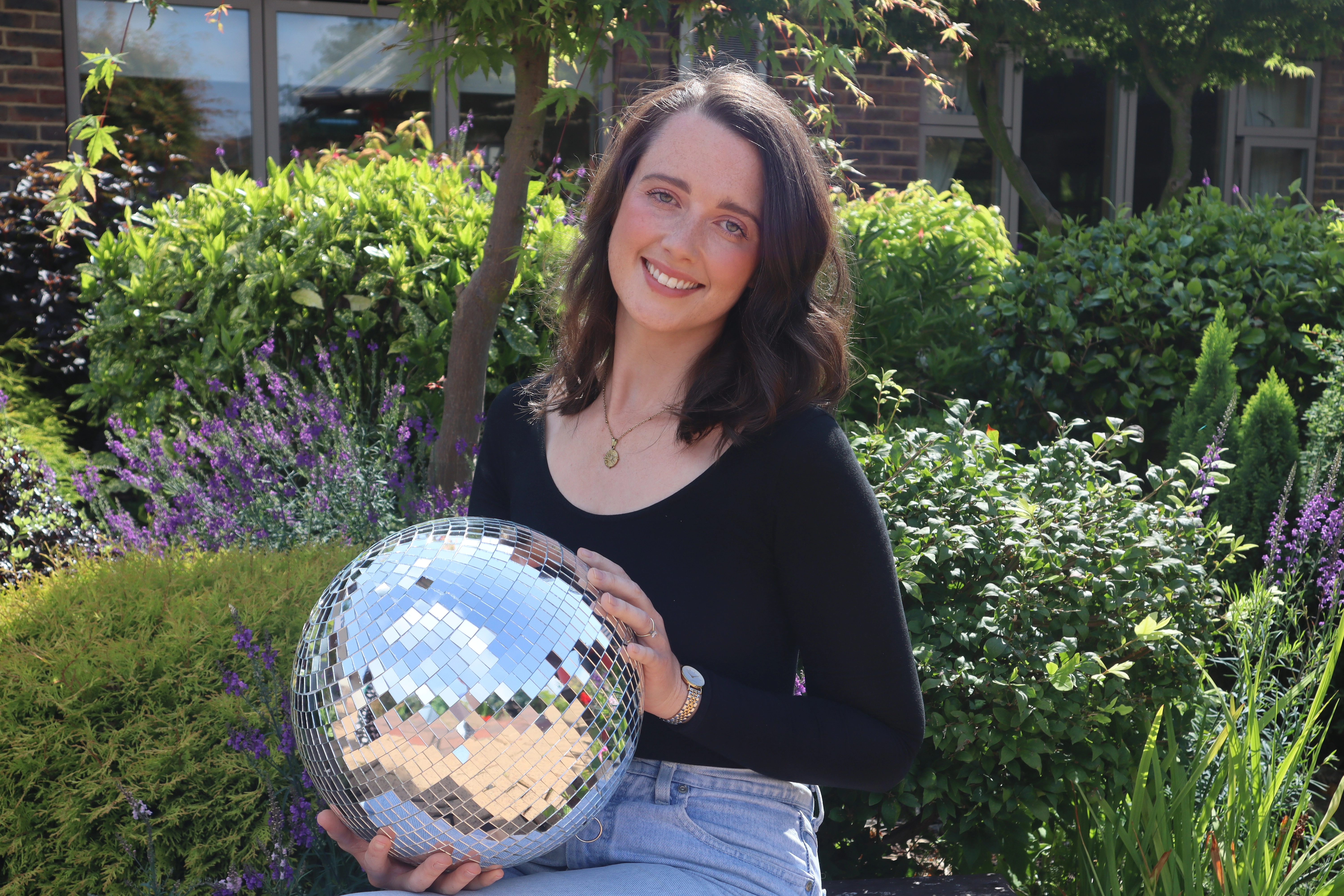 A photo of Charlotte holding the Strictly St. Rocco's Glitter ball